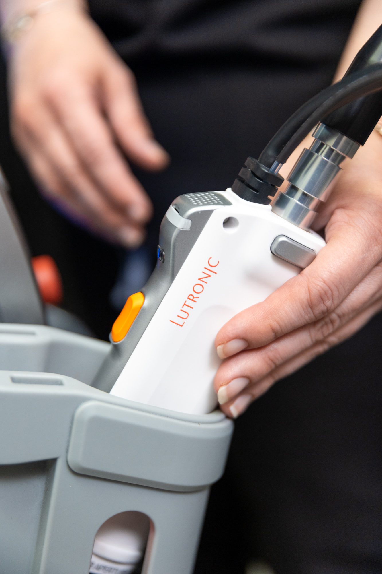 Hand holding Lutronic laser treatment device.