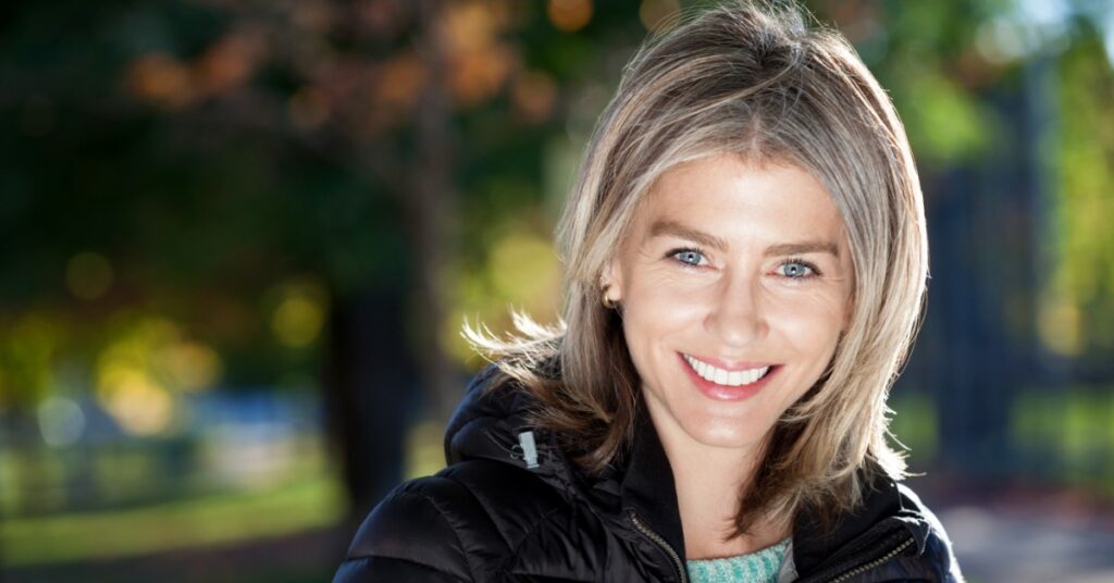 Smiling woman outdoors with glowing skin