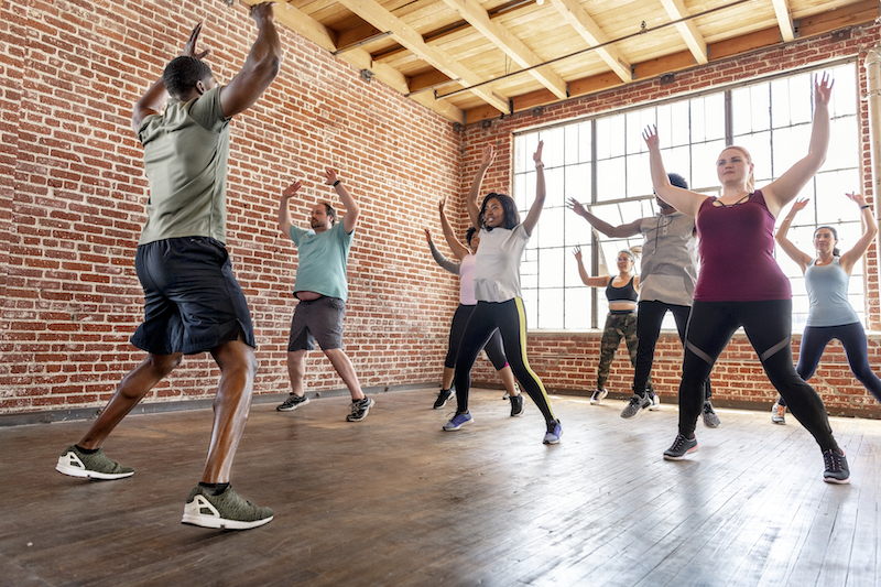 A group of people are doing jumping jacks at a fitness class paired with semaglutide weight loss in Fort Collins