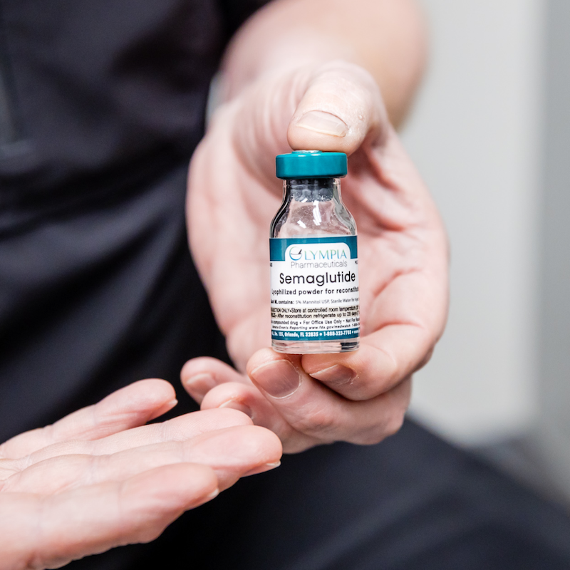 A woman is holding up a vial of semaglutide for medical weight loss in Fort Collins.