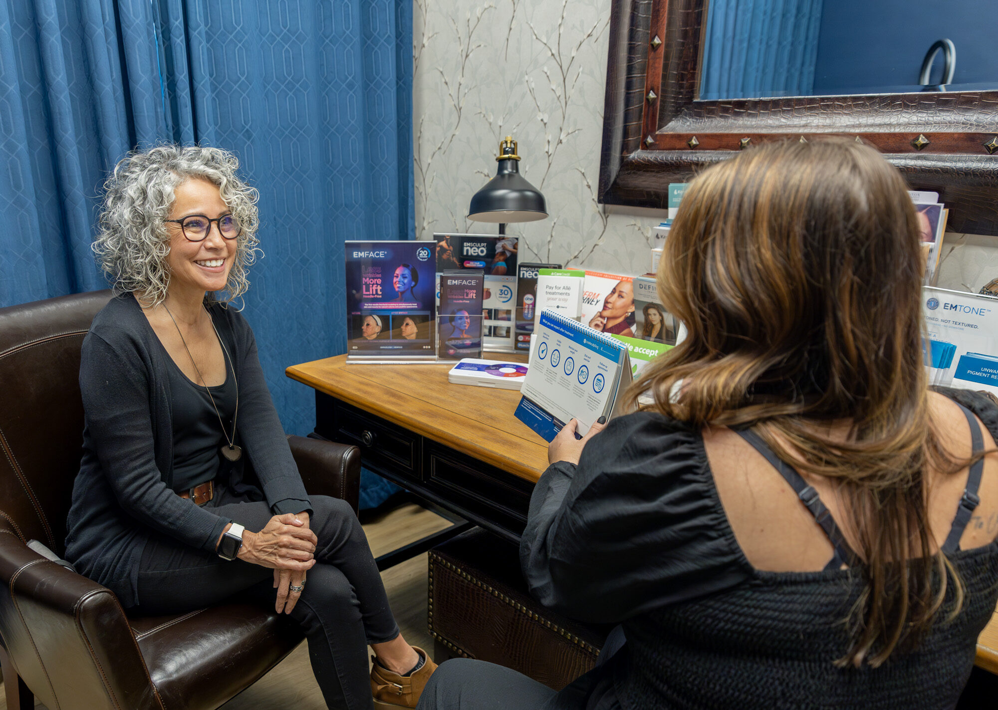 A woman is discussing ATTIVA skin tightening in Fort Collins at a Xanadu consultation.